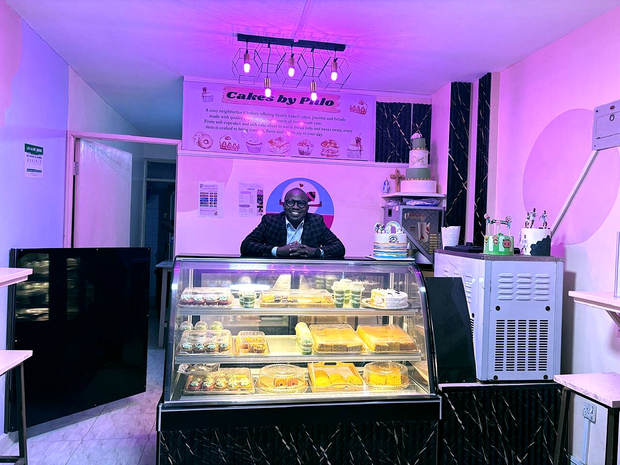 Phlo standing behind the bakery display case